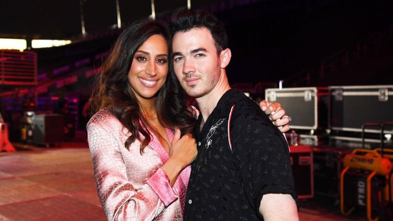 Danielle Deleasa 身穿粉色西装外套，拥抱 Kevin Jonas