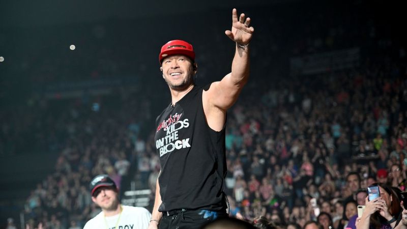 Donnie Wahlberg no palco acenando para a multidão