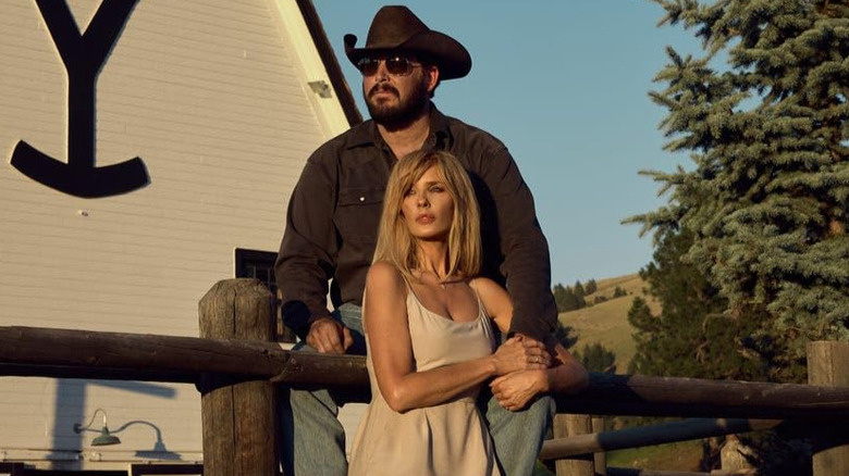   Beth Dutton de vestido branco segurando Rip Dutton