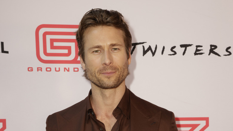   Jaqueta e camisa marrom Glen Powell