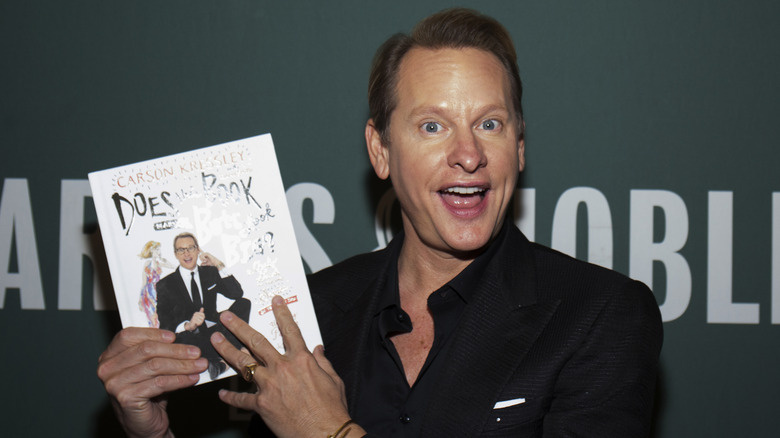  Carson Kressley posiert mit einem Exemplar seines Buches